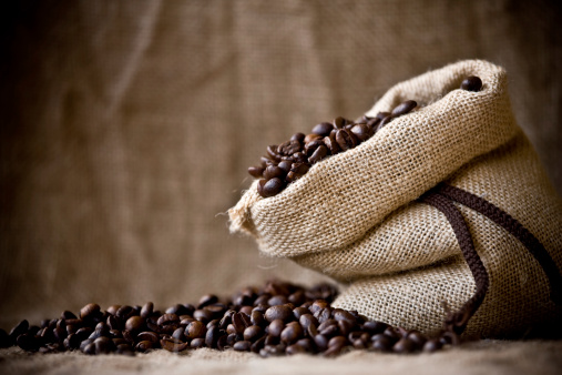 Burlap bag filled with coffee beans on burlap background. Canon 1Ds Mark III