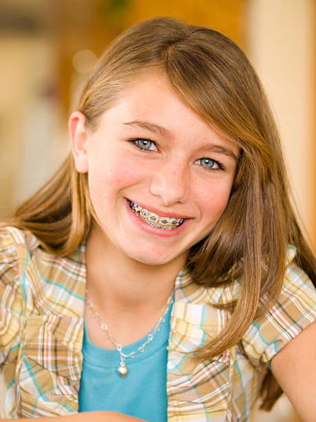 Blond girl with braces smiling at camera stock photo