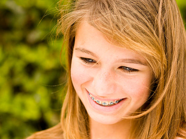 A beautiful girl with braces smiling outdoors stock photo
