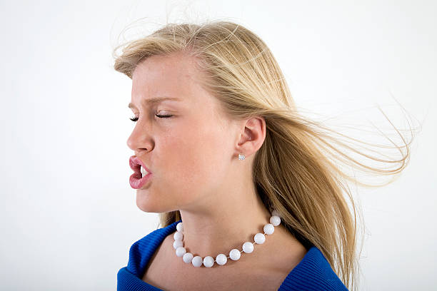 Puckering up for the kiss with wind flowing through her hair.