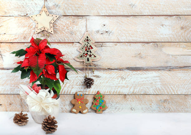 Empty rustic table with poinsettia, cookies and decorations,Christmas Eve concept, banner for display, holiday background. Christmas and New Year mockup for design and product display, selective focus
