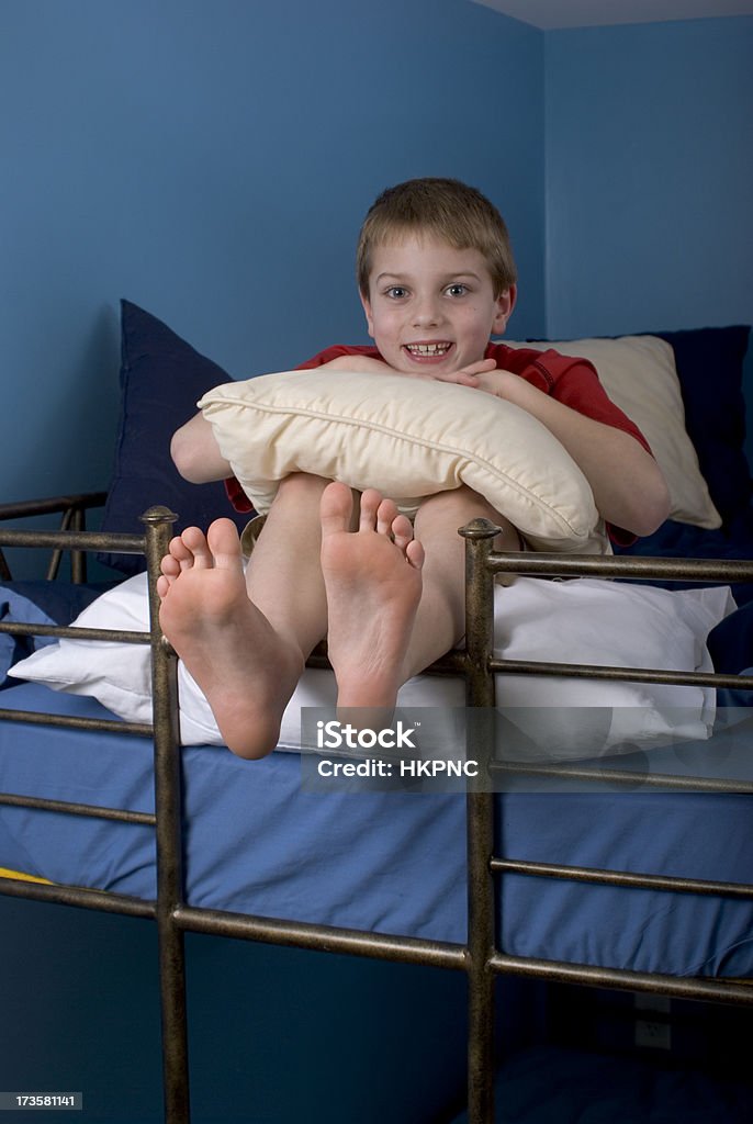웃는 행복한 남자아이 On 벙크 침대 위로 발을 매달기 - 로열티 프리 2 층침대 스톡 사진