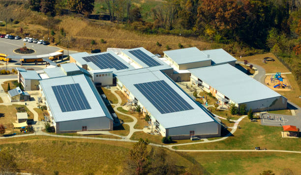 vista aérea del edificio de la escuela americana con techo cubierto con paneles solares fotovoltaicos para la producción de energía eléctrica - solar energy solar power station student alternative energy fotografías e imágenes de stock