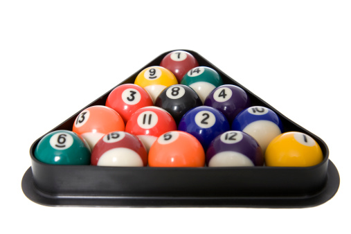 Pool balls racked up in a triangle isolated on white. Focus on the 8 ball.