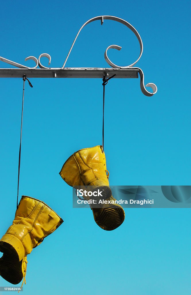 Yellow boots hängen von den Schuhbändern - Lizenzfrei Alt Stock-Foto