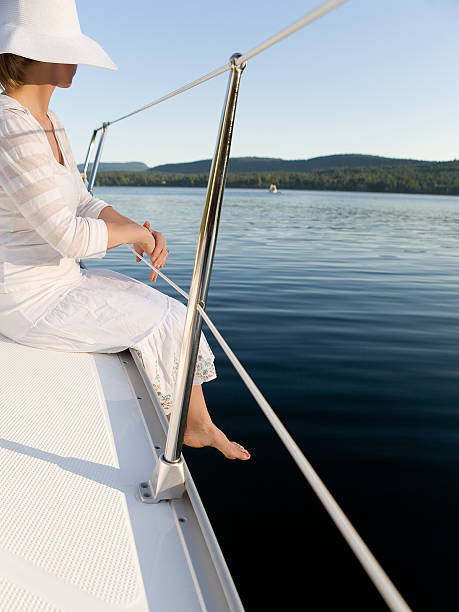 Donna in bianco seduto sulla barca Rail - foto stock