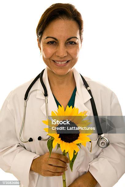 Feminino Adulto De Idade Mediana Médico Segurando Um Girassol - Fotografias de stock e mais imagens de Doutor