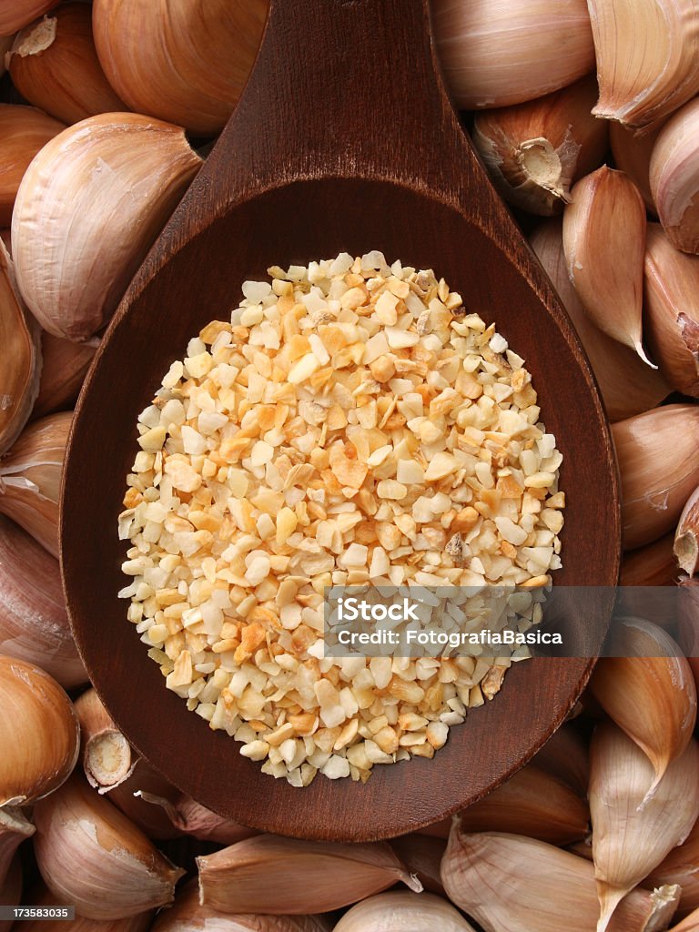 Dehydrated garlic Top view of wooden spoon with dehydrated smashed garlic over it. Shallow depth of field, focus on slices over spoon Dried Food Stock Photo