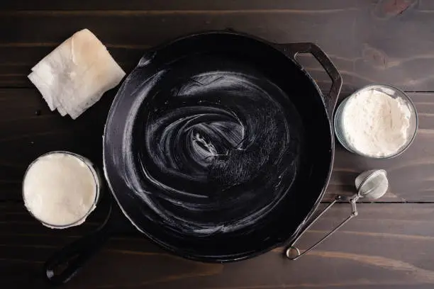 Hydrogenated vegetable fat rubbed inside a frying pan with a folded paper towel