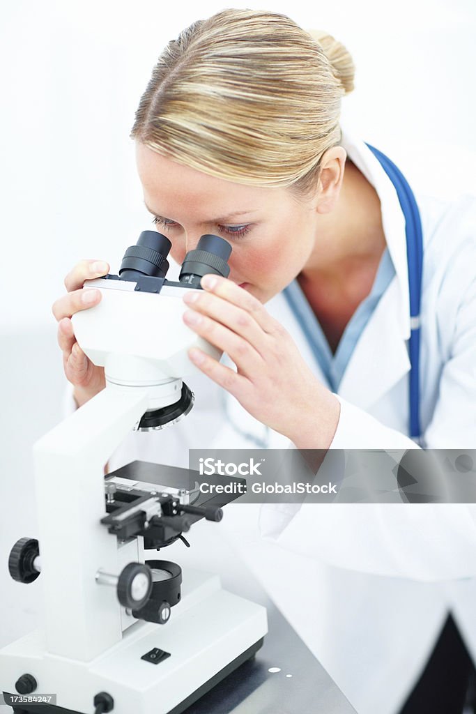 Женский доктор глядя через микроскоп - Стоковые фото 20-24 года роялти-фри