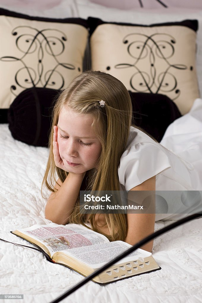 Młoda Dama leżenia na jej łóżku czytając scriptures - Zbiór zdjęć royalty-free (8 - 9 lat)