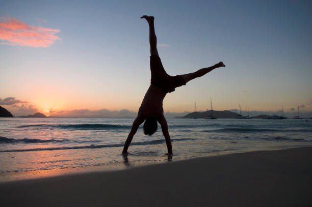 istock Silhouette of Man Doing Cartwheel on Sunset Beach 173585872