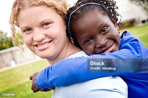 Foto de Duas Meninas Sorrindo E Abraçando Do Lado De Fora e mais fotos de stock de 12-13 Anos - 12-13 Anos, Abraçar, Menina