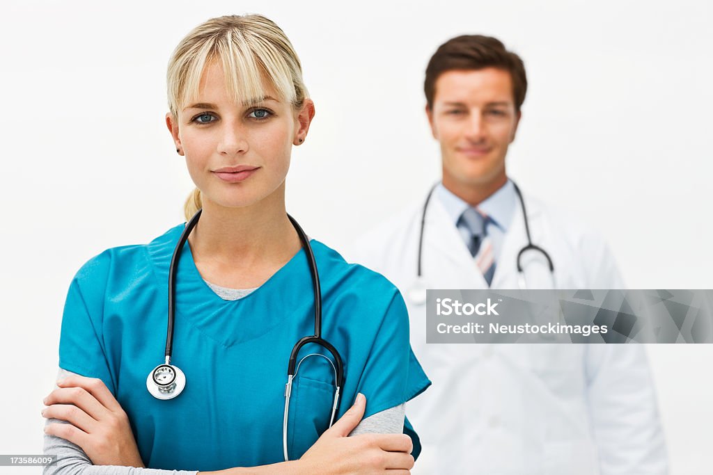Fiducioso dottore femminile con collega in background - Foto stock royalty-free di Sfondo bianco