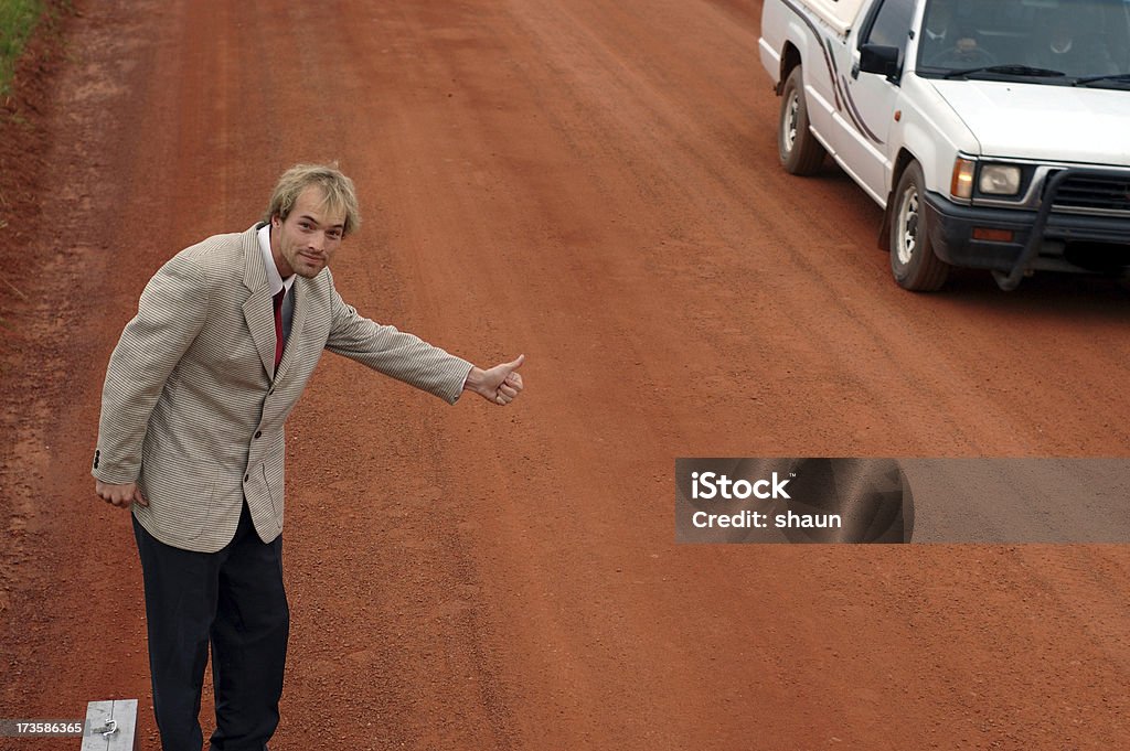 Travelling  Salesman Hitching business man, not having much luck. Briefcase Stock Photo