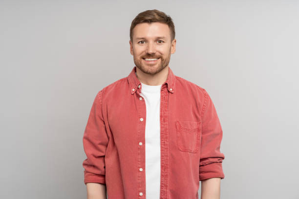 istock Pleased man smiling in high spirits looking confident at camera for ad offer, isolated studio wall. 1735864703