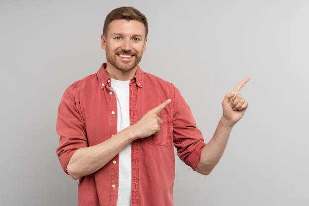 istock Excited happy positive young guy student pointing aside with fingers. Hand gesture, copy space 1735864960