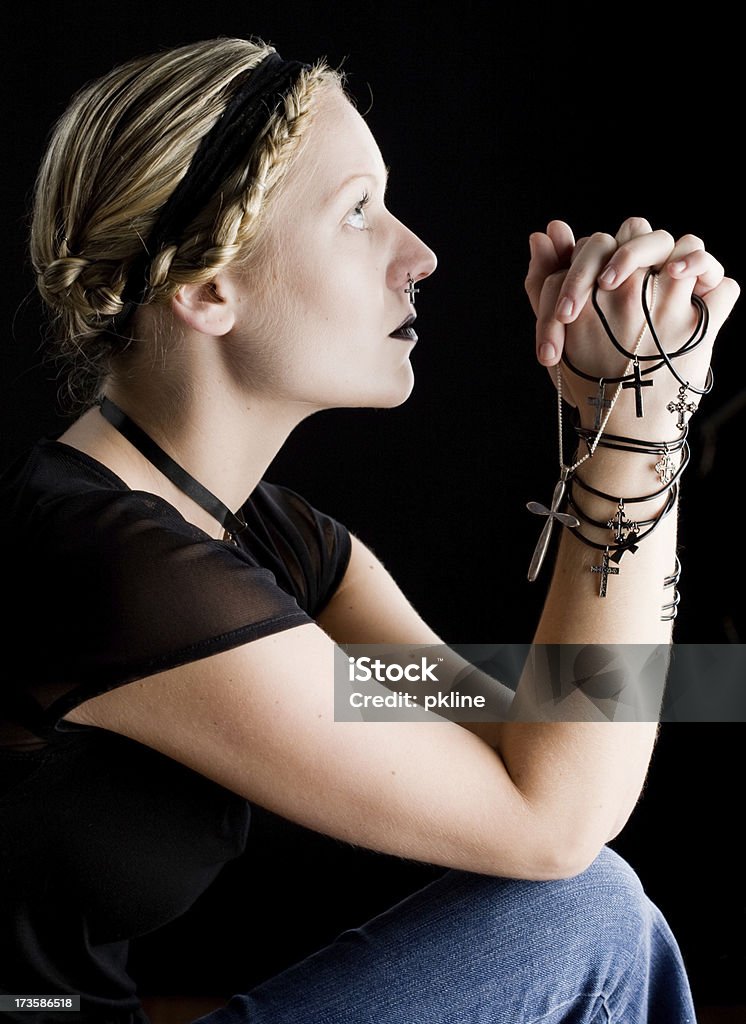 Young woman clasping crucifixes and looking up Young blond woman clasping crucifixes and looking up 20-24 Years Stock Photo