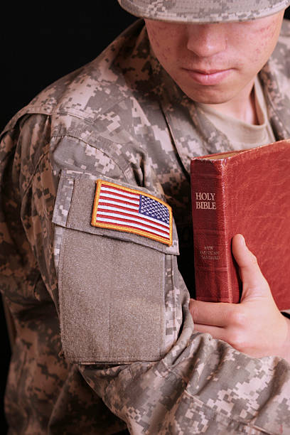 Soldier with Bible 19-year-old Army private holding a Bible and praying national day of prayer stock pictures, royalty-free photos & images