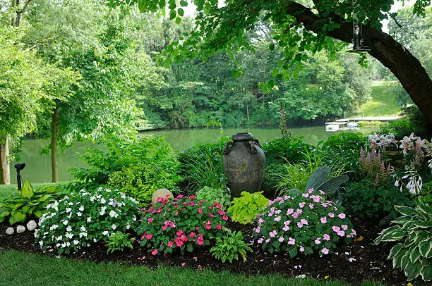 Beautiful well tended shade garden at the edge of a lake.