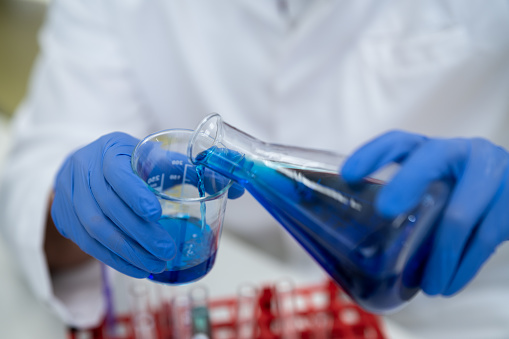 Personnel in the laboratory are mixing industrial glue, wearing gloves, professional protective clothing