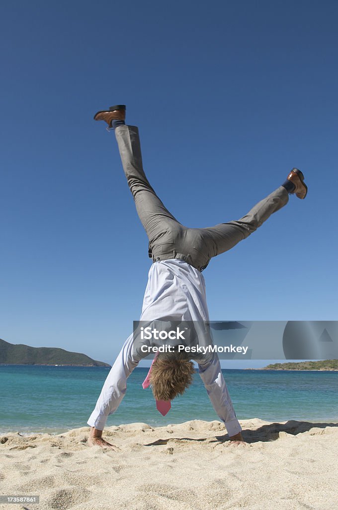 Homme d'affaires ne la roue sur la plage - Photo de A l'envers libre de droits