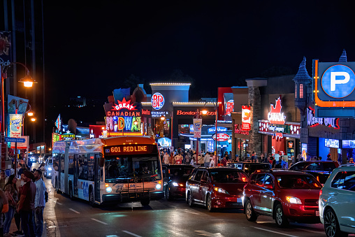 Niagara Falls, Canada - August 13, 2022: The busy Clifton Hill street in Niagara Falls at night. The area is a very popular attraction in the tourist oriented city.