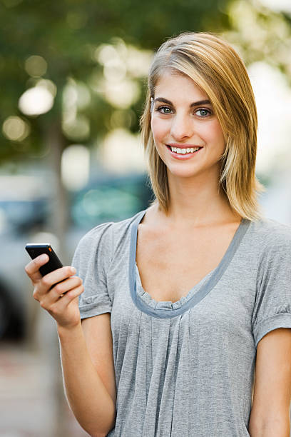 istock Young woman holding mobile phone 173589858