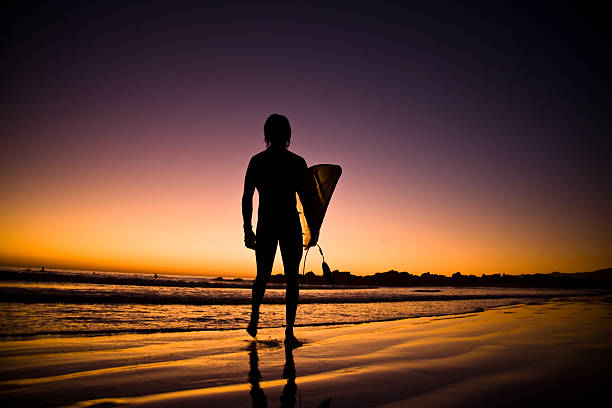 istock Lone surfer in the surf at sunset 173590585