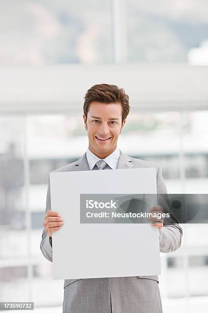 Hombre De Negocios Joven Feliz Sosteniendo Una Tarjeta En Blanco Blanco Foto de stock y más banco de imágenes de 20-24 años