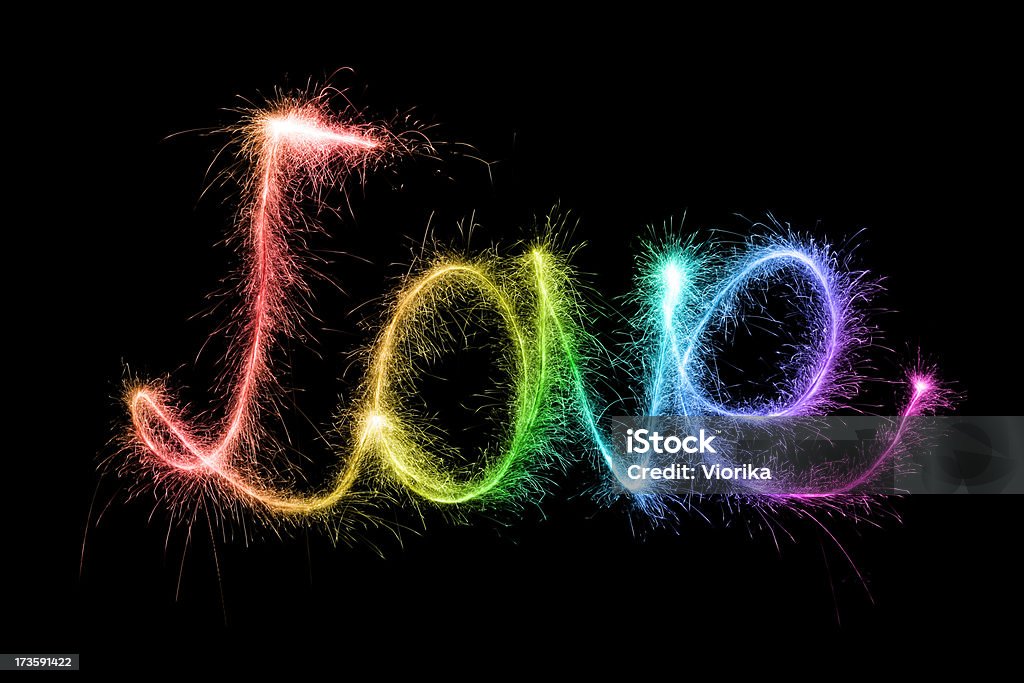 Sparkling Love LOVE written in sparkling rainbow letters on a pure black background. Black Background Stock Photo