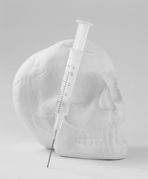 hypodermic syringe with skull. stock photo