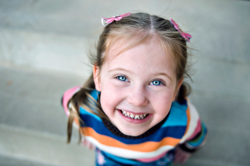 Children - Portrait of a cute little girl who is looking up at the camera and smiling.