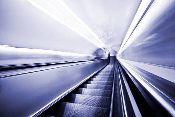 moving rolltreppe-motion verschwommene in blau-mehr wünsche unten - london england vanishing point underground diminishing perspective stock-fotos und bilder