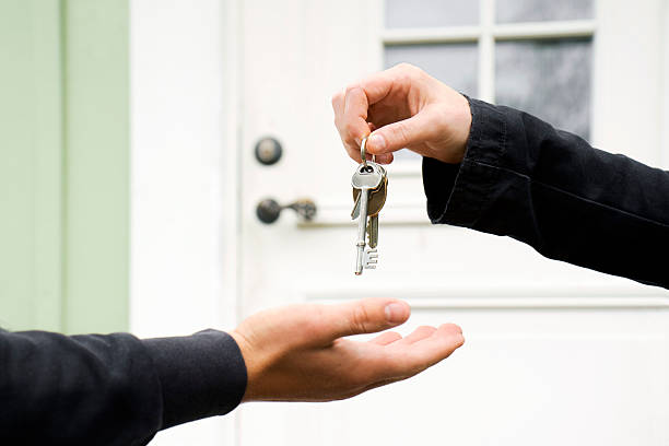 Key exchange Person exchanging keys with another. house key stock pictures, royalty-free photos & images