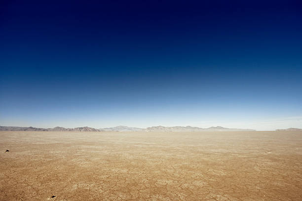 Vast Dry Land Flat desert scene with mountains at the horizon. desert stock pictures, royalty-free photos & images