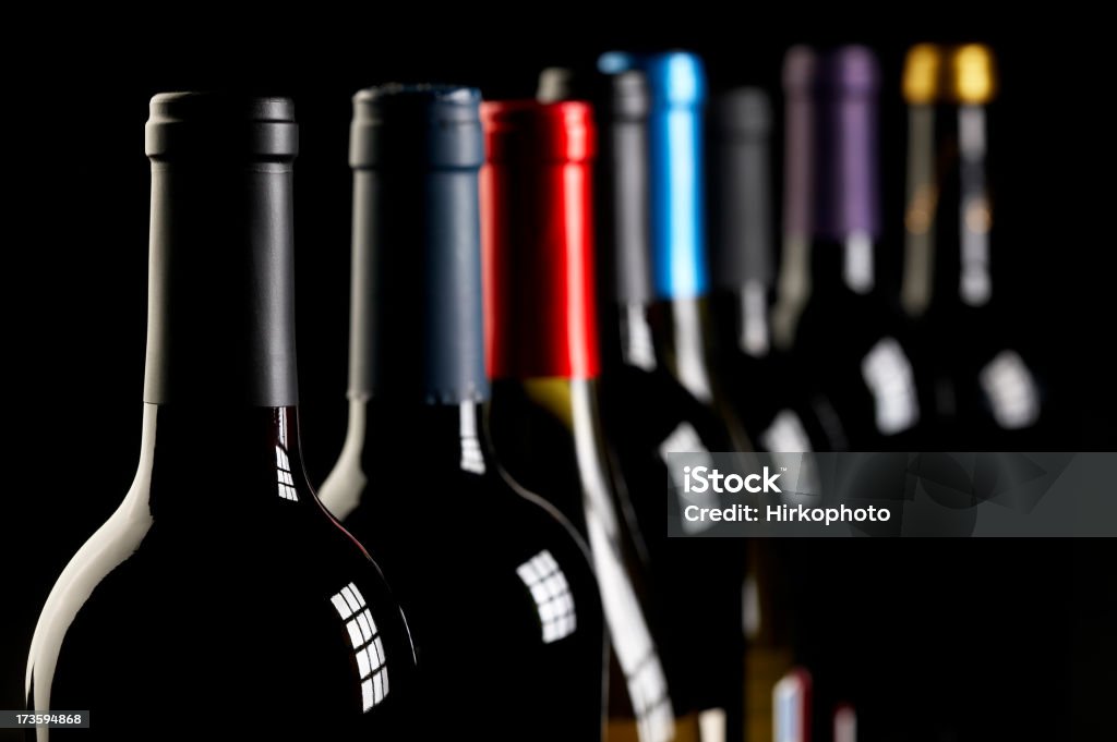 Wine bottles in a row on black Large group of wine bottles on a black background with window light reflections. No logos or labels are showing. Shot on Canon EOS 1Ds Mark 3 with 100mm lens.To see more of my wine images check my light box click here: Abstract Stock Photo