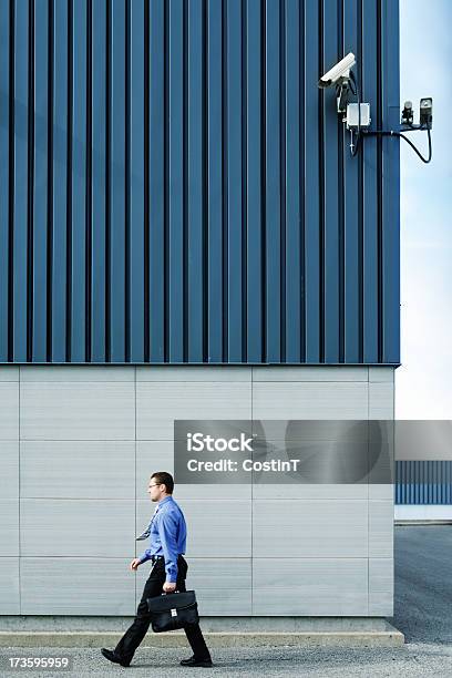 Businessman Walking Outside In Front Of Security Camera Stock Photo - Download Image Now