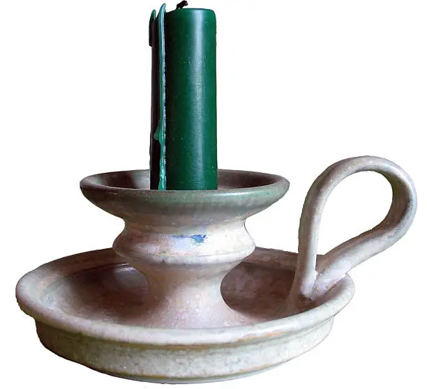 "Pottery Candleholder with green candle. Isolated, with white background."