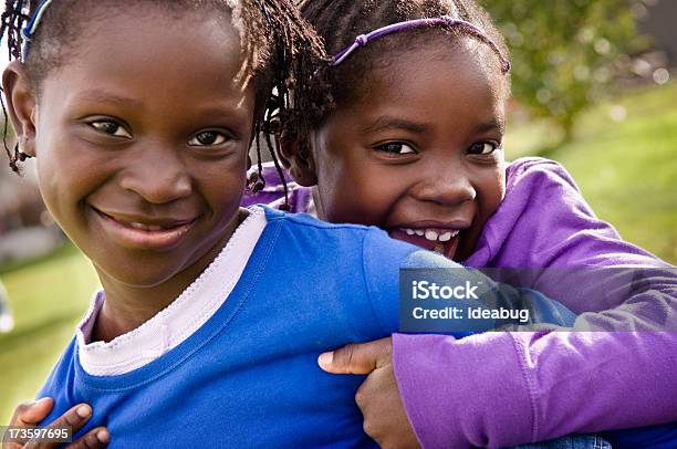 Due Bambine Felici Sorridenti E Abbracciare Allaperto - Fotografie stock e altre immagini di Abbracciare una persona