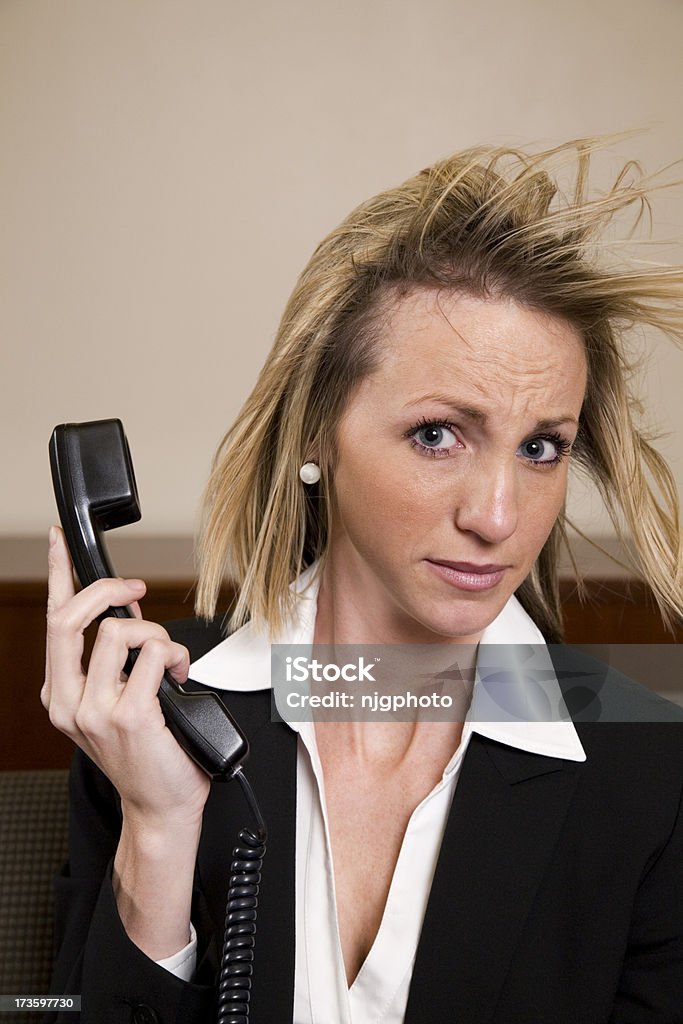 Office Series Businesswoman being yelled at by someone she is talking on the phone with. She is holding the phone away from her ear.Canon 5D processed from RAW file.Please see the light box link for more. Adult Stock Photo