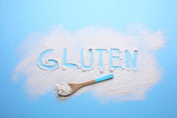 istock Spoon and word Gluten written with flour on light blue background, flat lay 1735982964