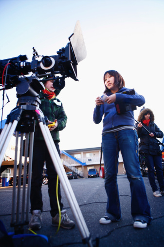 2nd Assistant Camera records important information on the camera report as the boom operator prepares the boom and the other ac has just measured for focus.More filmmaking images: