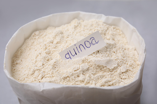 Sack with quinoa flour on light table, closeup
