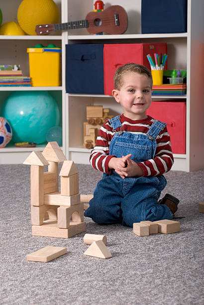 istock Young Boy Building With Wooden Toy Blocks Vertical Looking Happy 173600242
