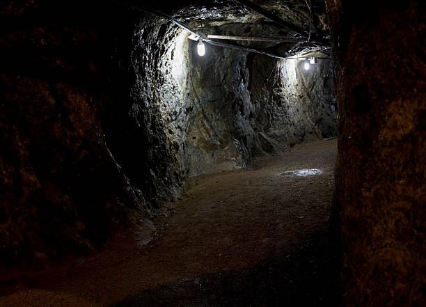 istock Dark Curving Cave-like Mine Tunnel Lit with Light Bulbs 173600327