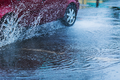 Splashes of water. Puddle on road. Rainy weather. Rain.