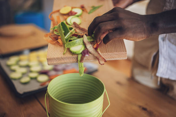 Man in a domestic kitchen, engaged in sustainable cooking and recycling. She's preparing a healthy, organic meal, chopping vegetables, and emphasizing zero waste practices. It highlights the importance of environmentally conscious lifestyles.