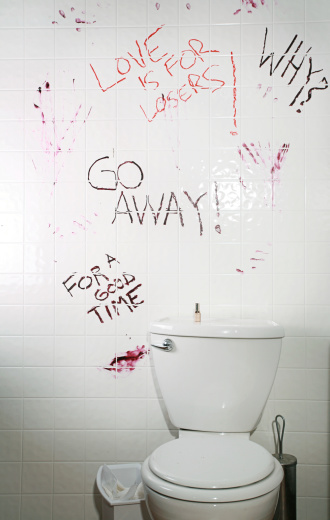 bathroom with lipstick graffiti