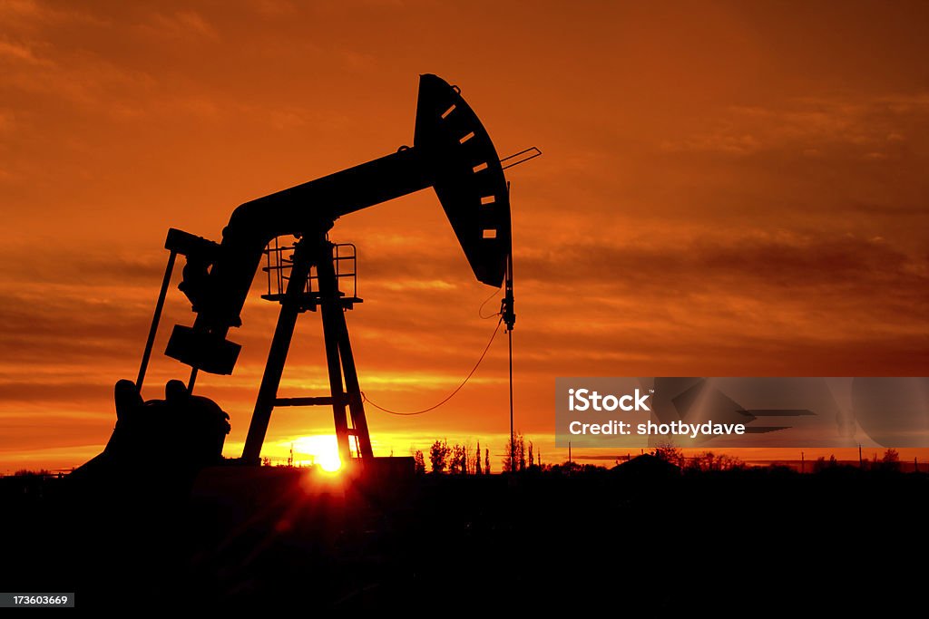 Pumpjack as the sunrises A pumpjack silhouetted against a sunrise.  Part of a series of the same pumpjack Geologist Stock Photo
